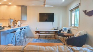 A modern living space with a kitchen area, a dining table, and a seating area with a sofa and chairs. - 2 Bdrm/2 Bath, Sleeps 6, Pool, Balcony, Wi-Fi, TVs (Ocean City)