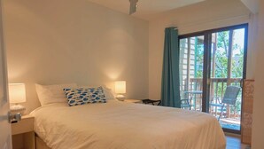 A bedroom with a large bed, two bedside lamps, a chair, and a view of the outdoors through a sliding glass door. - 2 Bdrm/2 Bath, Sleeps 6, Pool, Balcony, Wi-Fi, TVs (Ocean City)