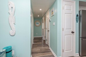 Stylish hallway with a door, mirror, and seahorse decoration.