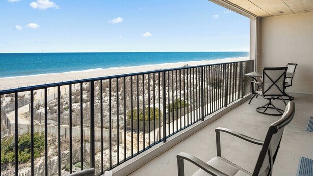 Ein Balkon mit Blick auf Strand und Meer.