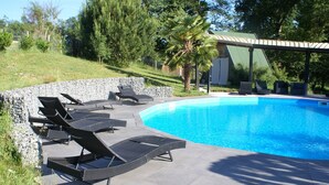 A swimming pool with lounge chairs and a pergola. - eco-gîte with SPA in the heart of nature, horse riding, Limousin (DOMPIERRE-EGLISES)