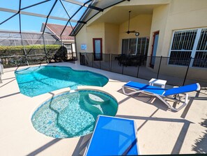 A pool area with two hot tubs and lounge chairs.