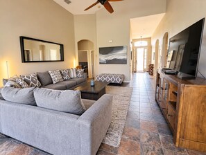 Lounge with L-shaped sofa, Smart TV, ceiling fan, views to the pool deck