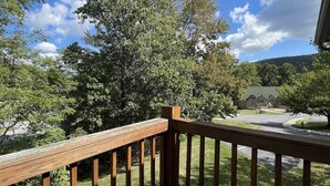 A wooden deck with a view of a residential area, including houses and trees. - 14022 Maple Way (Mercersburg)
