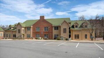 A row of multi-story buildings with a parking lot in front.