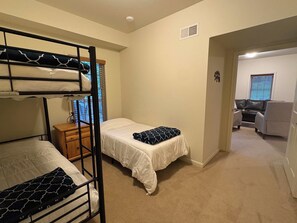 Une chambre avec des lits superposés, un bureau et un canapé.