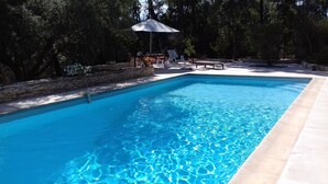 A rectangular swimming pool with clear blue water, surrounded by a stone wall and a tiled deck. - Villa de prestige au cœur d’un domaine privé
Piscine privée & sérénité absolue (Le Muy)