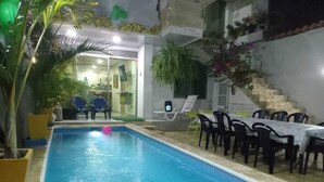 An indoor swimming pool with a table and chairs, surrounded by potted plants and a staircase. - Casa Playa Arreboles is located in front of the beach, ideal for families. (La Boquilla)