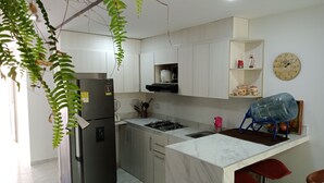 A modern kitchen with a refrigerator, stove, sink, and marble countertop. - Casa Playa Arreboles is located in front of the beach, ideal for families. (La Boquilla)