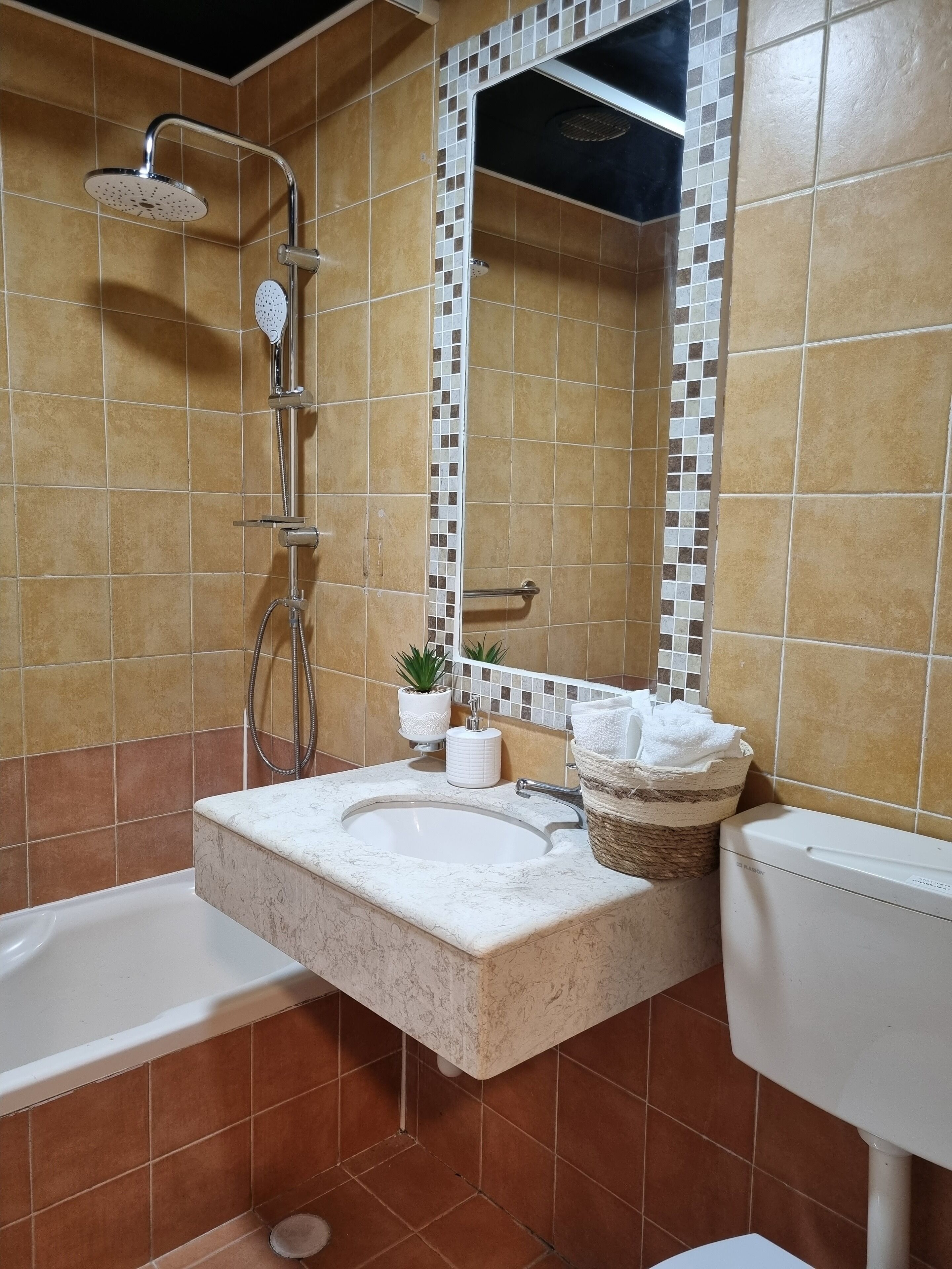 A bathroom with a bathtub, a sink, a toilet, and a shower.