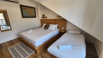 Ein Schlafzimmer mit zwei Betten, einem hölzernen Kopfteil, einer Karte an der Wand und einem Spiegel.