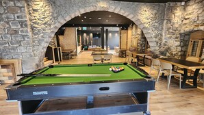 A billiards table in a rustic room with stone walls and wooden furniture. - Tiberia hotel (Tiberias)