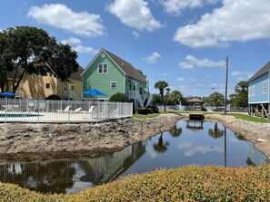 Un quartier résidentiel avec une piscine, une clôture blanche et des maisons.