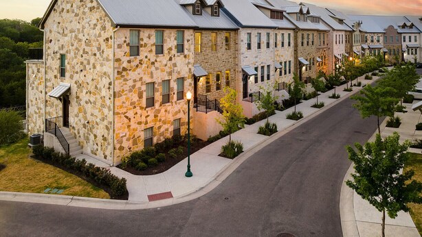 A row of stone buildings with a modern design, featuring multiple windows and a central light pole. - Your Home Away From Home in the Texas Hill Country, Georgetown TX (Georgetown)