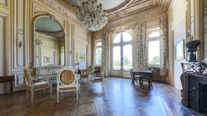 Ein prachtvoller Raum mit kunstvollen Möbeln, einem Chandelier und großen Fenstern.