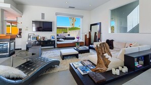 A modern living room with a fireplace, a large TV, and a cozy seating area. - 25% Off Sep 3-6 Perfect 4 Families -Pool, Jacuzzi* (Palm Springs)