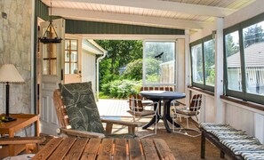 Relax in a warm and inviting space with a comfortable seating area, wooden bench, and large window offering a view of the outdoors.