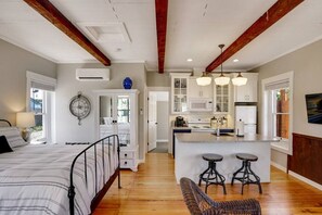 Une chambre spacieuse avec un grand lit, une armoire et une horloge au mur.