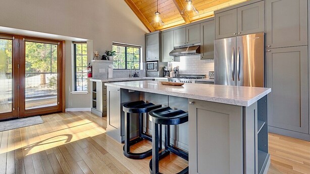 A modern kitchen with a large island, stainless steel appliances, and a wooden ceiling. - Private Ski, Lake & Golf Chalet! Walk to Lake (Tahoe Vista)