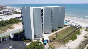 A modern hotel with a pool area, located near a beach with a view of the ocean. - Beachfront Bliss! Oceanfront Pool! Great Location!  Ocean Trillium 702 (New Smyrna Beach)