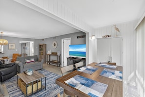 A modern living room with a television, sofa, coffee table, and dining area with placemats. - 2 Bed 2 Bath Centrally Located (Siesta Key)