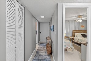A hallway leading to a bedroom with a bed, a nightstand, and a ceiling fan. - 2 Bed 2 Bath Centrally Located (Siesta Key)