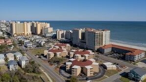 Paesaggio costiero con edifici alti, una spiaggia e un mix di edifici residenziali e commerciali.