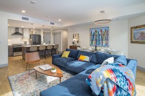 A modern living room with a sofa, coffee table, and a dining area with chairs. - Timber Fox located downtown Winter Park 1307 (Winter Park)