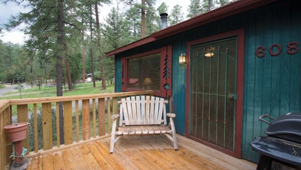 A wooden deck with a white bench, a grill, and a door with the number 608. - Roadrunner - Historic Upper Canyon, Priv Hot Tub, Cozy (Ruidoso)