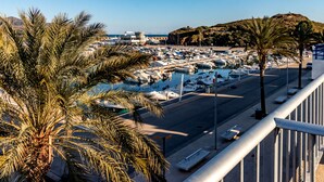Ein Yachthafen mit vertäuten Booten, Palmen und blauem Himmel.