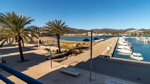 A coastal promenade with palm trees, a playground, and a marina with boats. - Port de Llançà 34 - Apartment with sea views (Llança)
