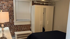 A bedroom with a bed, a desk, a wardrobe, a window with blinds, and a ceiling fan. - Adorable 1st floor apartment 2 blocks to the beach. (Ventnor City)