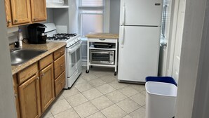 A compact kitchen with wooden cabinets, a gas stove, a built-in oven, a microwave, and a refrigerator. - Adorable 1st floor apartment 2 blocks to the beach. (Ventnor City)