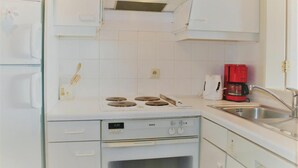 A kitchen with white cabinets, a Bosch stove, a red coffee maker, and a sink. - Golf & Beach C2 - beautiful 3-bedroom apartment 50 m from the beach (De Haan)
