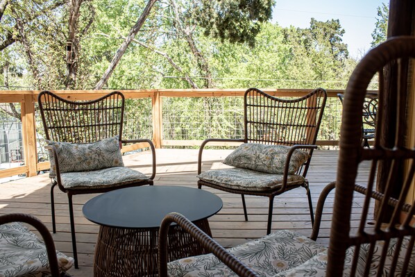 Une terrasse extérieure aménagée avec des meubles en osier, notamment deux chaises et une petite table.