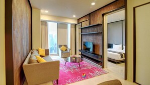 Une chambre d’hôtel moderne équipée d’un canapé, d’une télévision et d’un lit.