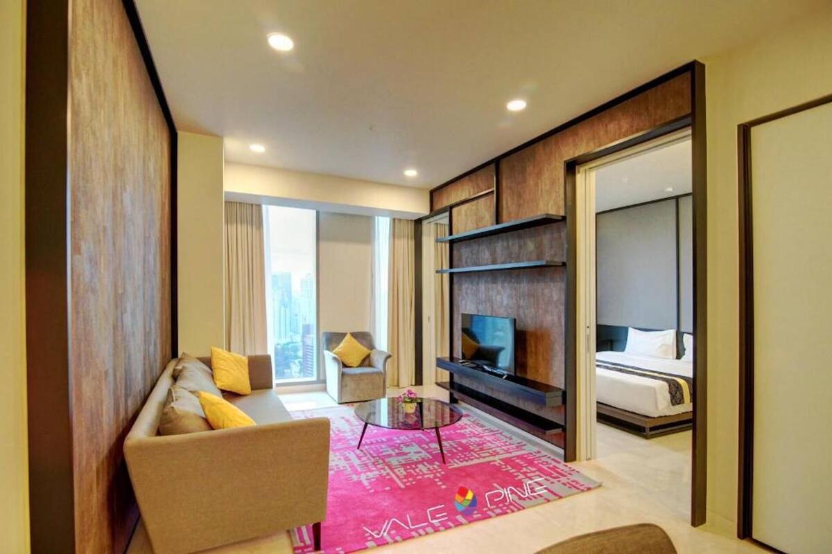 Ein modernes Hotelzimmer mit Sofa, Fernseher und Bett.