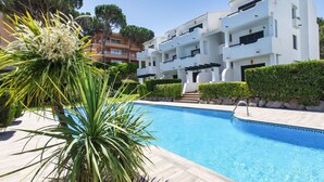 Ein modernes Gebäude mit Pool, umgeben von Grün und blauem Himmel.