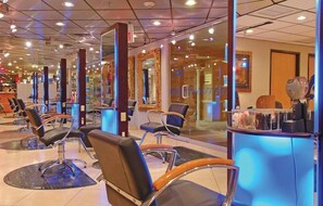 A salon with multiple hairdressing stations, each with a chair and a mirror.