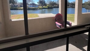 Un espacio al aire libre techado con vistas a un lago y casas al fondo.