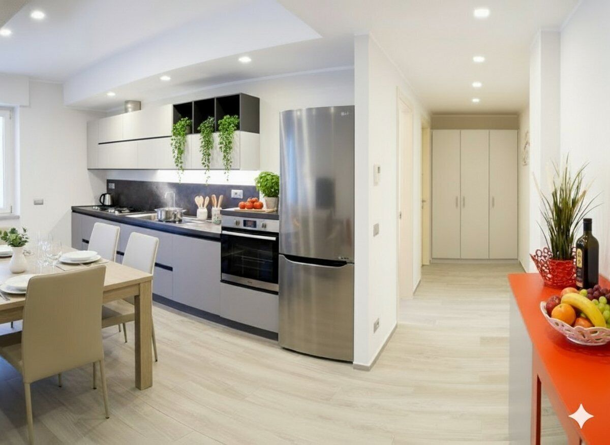 A modern kitchen with white cabinets, stainless steel appliances, and a dining area with a table and chairs.