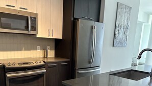 Una cocina moderna con electrodomésticos de acero inoxidable, suelo de madera y un diseño minimalista.