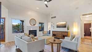A spacious living room with a fireplace, two sofas, a coffee table, and a ceiling fan. - El Conquistador/Golf+Mnt+LakesVIEWS/Sleeps4 (Oro Valley)