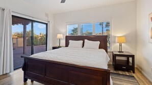 A bedroom with a large bed, two bedside tables with lamps, a ceiling fan, and a view through a sliding glass door to an outdoor area. - El Conquistador/Golf+Mnt+LakesVIEWS/Sleeps4 (Oro Valley)