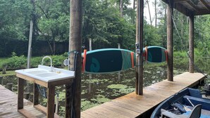 Een houten terras met een gootsteen en een boot afgemeerd.