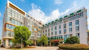 A modern hotel with a central courtyard, multiple floors, and a green sign indicating the name. - Greentree Inn Nanjing Maqun Srt Ningzhi Rd Shell H (Nanjing)