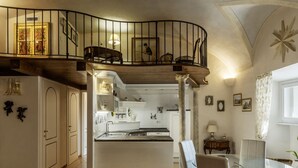 Un vaste espace de vie comprenant une cuisine, une table à manger et un escalier menant à l’étage supérieur.