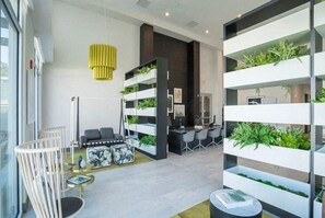 Welcome to a serene space with a modern desk, greenery, and a unique light fixture.