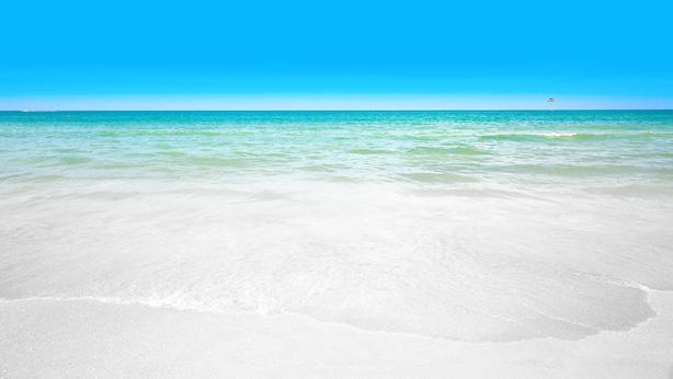 Una spiaggia con acque cristalline turchesi e sabbia bianca.