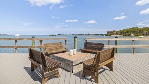 Un pontile di legno con un tavolo e quattro panche affacciato su uno specchio d'acqua.